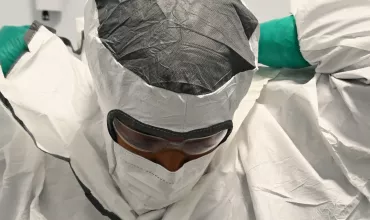 A highly trained Novartis specialist dresses in full personal protective equipment to work on the radioligand therapy production line