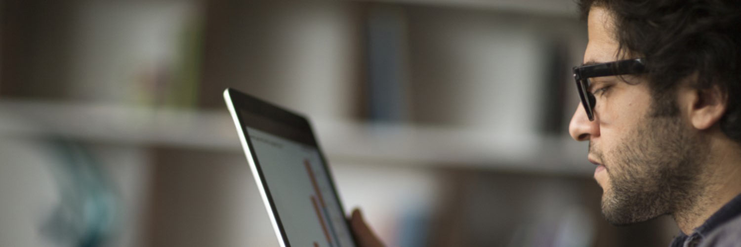 Man looking at statistical graph on laptop