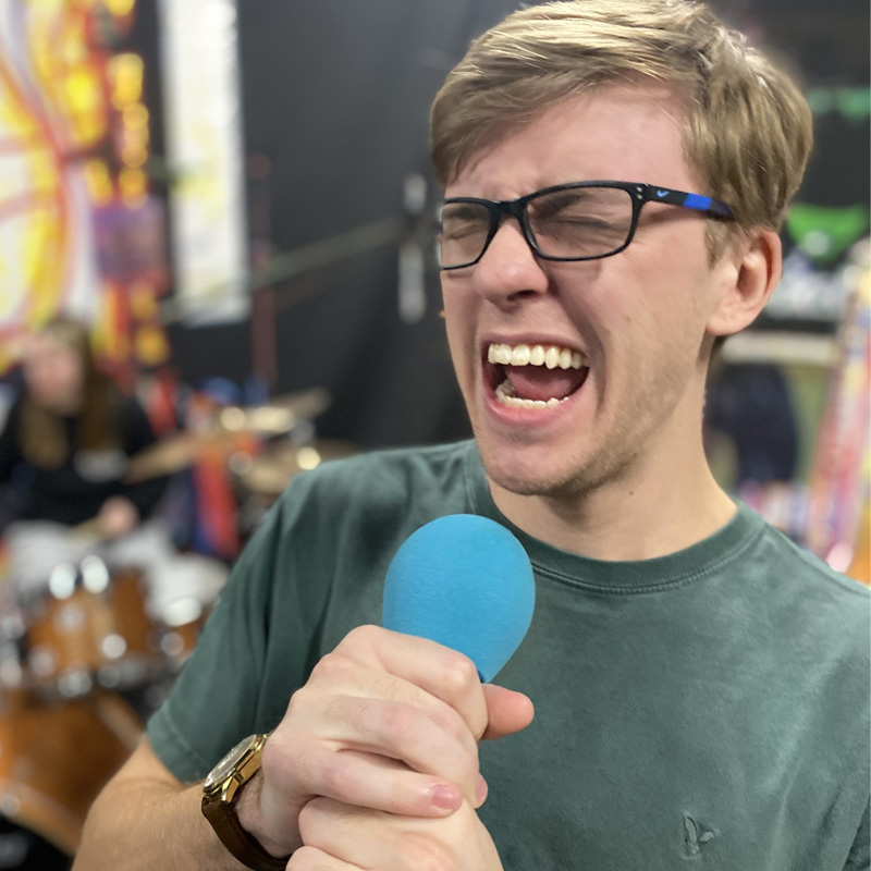 Student vocalist singing into microphone in Purdue's new JamSpace