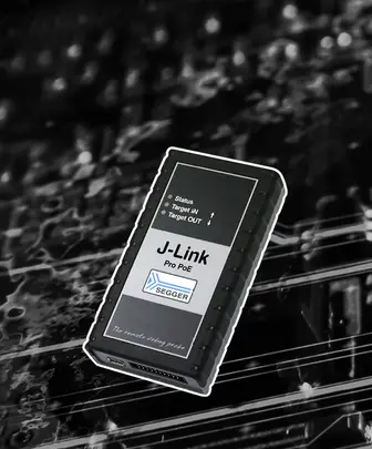 A black device labeled "J-Link Pro PoE" with indicator lights for "Status," "Target IN," and "Target OUT." It is used for remote debugging in electronics. The background features subtle circuit patterns, emphasizing the device's technological context.