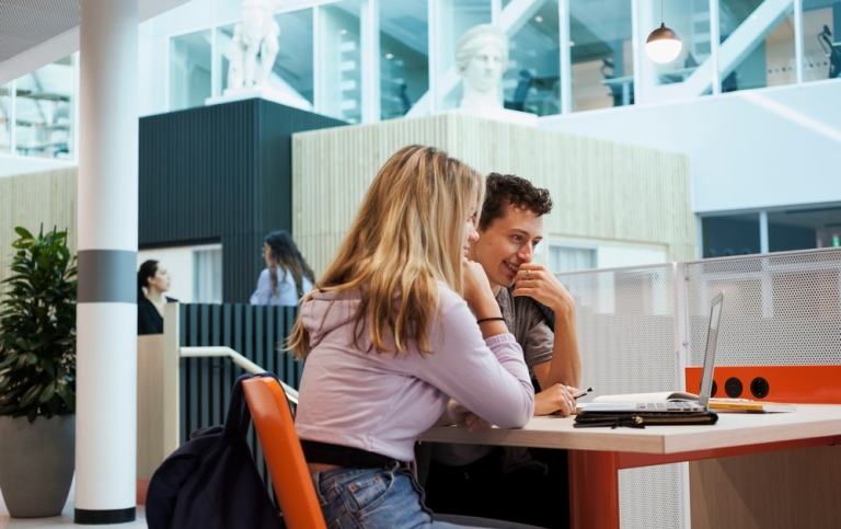 Två studenter framför en bärbar dator på campus Albano.