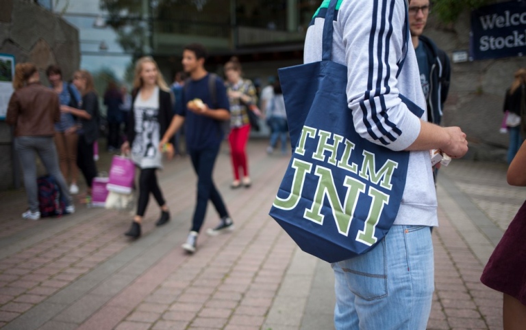 Student med SU-kasse utanför Aula Magna.