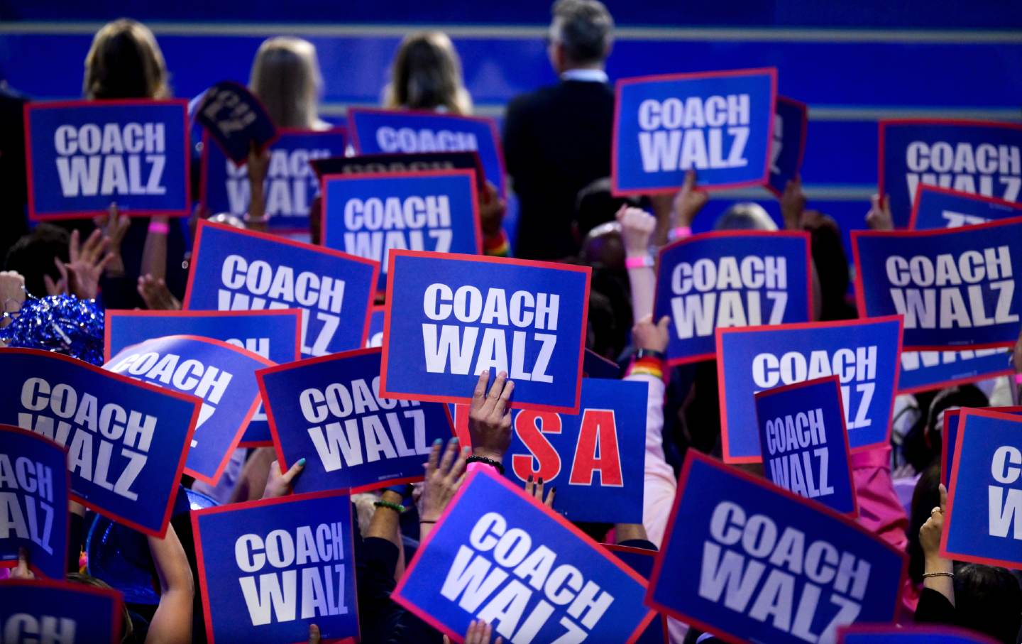 Delegates hold “Coach Walz” signs during the Democratic National Convention at the United Center in Chicago on August 21, 2024.