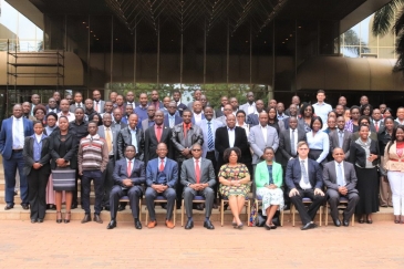 Over 50 people in a group photo at the entrance to a building in Zimbabwe.