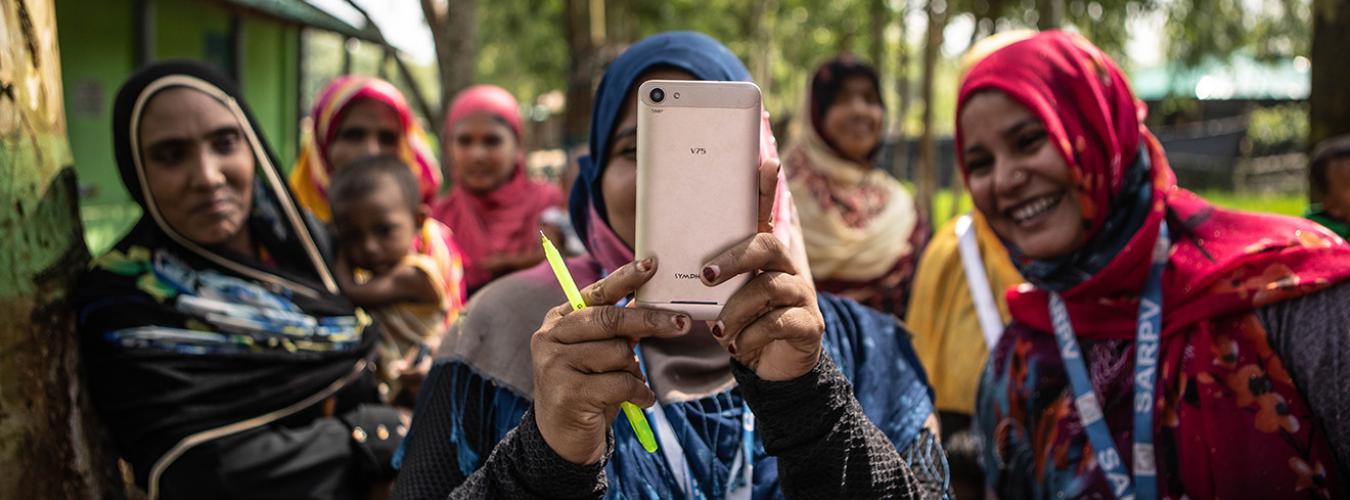 Women taking a picture from a mobile in Cox's Bazar