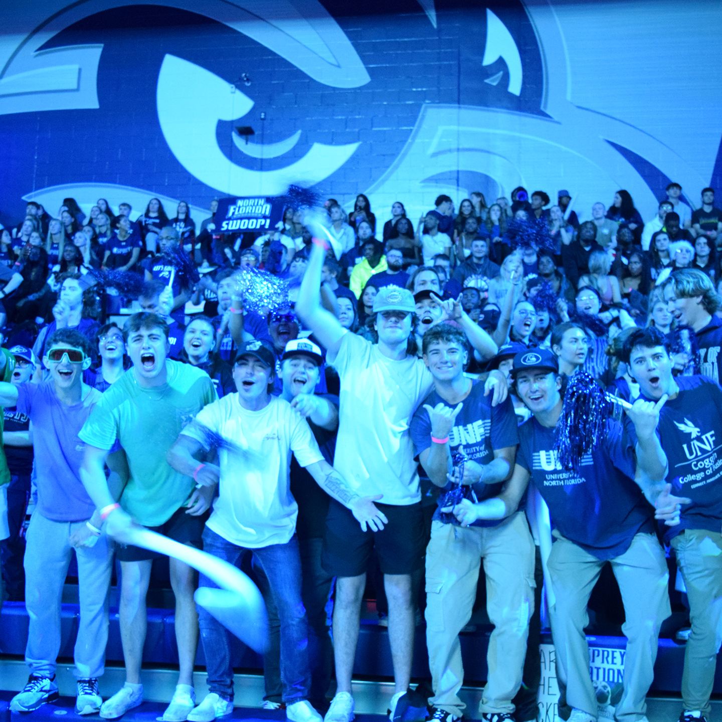 student basketball fans in the stands cheering